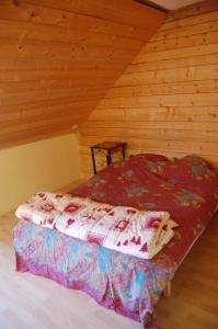 a bed in a cabin with a wooden ceiling at Maison de la Combe des Cives in Chapelle-des-Bois