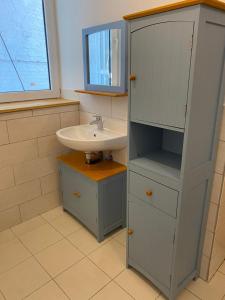 a bathroom with a sink and a cabinet at Ferienwohnung am grünen Band, Gretchen in Wittingen