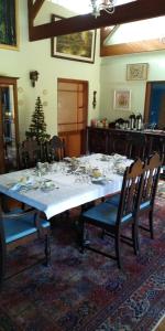 mesa de comedor con mantel y sillas blancas en Landhaus, en Santo Antônio do Pinhal
