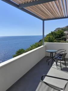 een balkon met een tafel en stoelen en de oceaan bij Studio 87 in Dubrovnik
