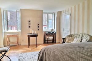 um quarto com uma cama, uma mesa e janelas em Le panoramique, au centre historique de Dijon em Dijon
