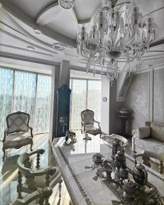 un soggiorno con lampadario pendente, tavolo e sedie di Hotel "Mandarin Clubhouse" a Charkiv