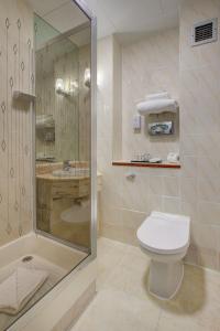 a bathroom with a shower and a toilet and a sink at The Rathbone Hotel, Fitzrovia in London