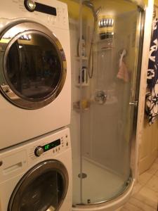 a washing machine and a shower in a bathroom at Beach Colony Ocean Front Executive Suite in Myrtle Beach