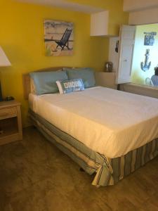 a bedroom with a large bed in a yellow room at Beach Colony Ocean Front Executive Suite in Myrtle Beach