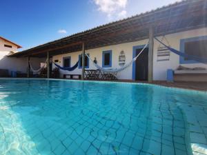 a swimming pool in front of a house at Pousada Casa Feliz Maxaranguape in Maxaranguape