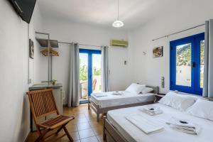 a room with two beds and a chair in it at Giannis studio Agia Roumeli in Agia Roumeli