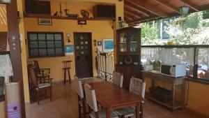 a dining room with a wooden table and chairs at Vila São Pedro in Ilhabela