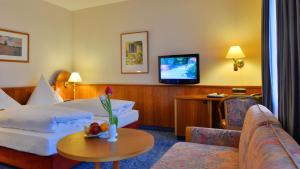 a hotel room with a bed and a tv at Hotel Ilbertz in Cologne