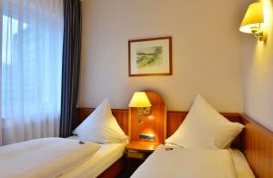 a hotel room with two beds and a window at Hotel Ilbertz in Cologne +52 photos