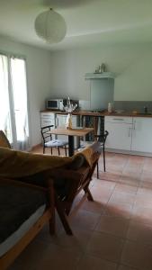 ein Wohnzimmer mit einem Tisch und einer Küche in der Unterkunft Studio des Ventoulines in Cénac-et-Saint-Julien