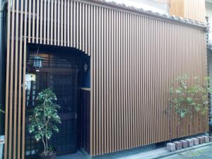 a building with a door and a tree in front of it at Kyoto Villa Kotone in Kyoto
