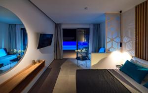 a hotel room with a bed and a mirror at Zoes Hotel & Suites in Faliraki