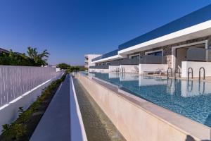 a large swimming pool next to a building at Zoes Hotel & Suites in Faliraki