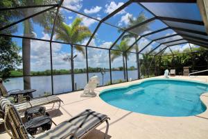 a swimming pool in a greenhouse with a view of the water at Villa Princess in Cape Coral