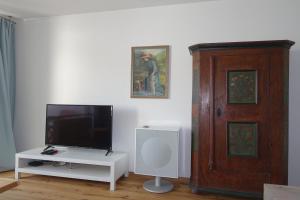 ein Wohnzimmer mit einem Flachbild-TV und einem weißen Tisch in der Unterkunft Nemos Paradies - TOP Lage am See und Sbahn in Pöcking