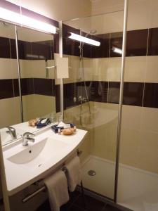 a bathroom with a sink, mirror, and shower stall at The Originals City, Hôtel Rey du Mont Sion, Saint-Julien-en-Genevois Sud (Inter-Hotel) in Saint-Blaise