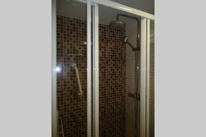 Un baño con ducha con puerta de cristal. en Cueva Santa Cruz, en Alicante