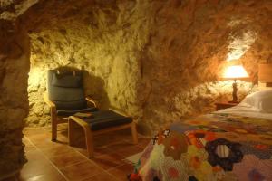 a bedroom with a bed and a chair and a lamp at Cueva Santa Cruz in Alicante