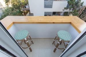 2 sedie sedute sotto un tavolo sul balcone di PORT CITY HAIFA - BAT GALIM 25 mtrs from the beach & Rambam a Bat Gallim