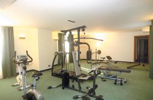 a gym with several tread machines in a room at Hotel Principe in Pomezia