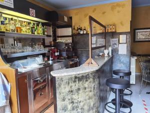 a bar in a restaurant with a counter and stools at Hotel Bonola in Milan