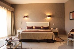 ein Schlafzimmer mit einem Bett und einem Kreuz an der Wand in der Unterkunft Hotel Layfer del Centro, Córdoba, Ver in Córdoba