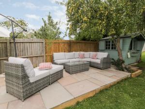 eine Terrasse mit zwei Sofas und einem Zaun in der Unterkunft The Willows in Melton Mowbray