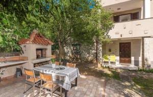 a patio with a table and chairs and a house at Holiday house Desy Tar in Tar