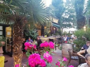 een groep mensen in een restaurant met roze bloemen bij Pension Der Kretaner in Berlijn