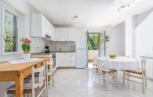 a kitchen and dining room with a table and chairs at Holiday house Desy Tar in Tar