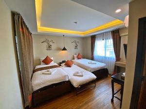 Un pat sau paturi într-o cameră la Fang Chiang Mai โรงแรมแฟงเชียงใหม่