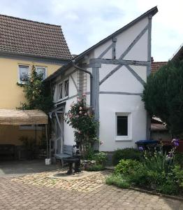 Wehrheim的住宿－Romantisches Gästezimmer - Zentralgelegen，庭院内白色的房子,设有长凳