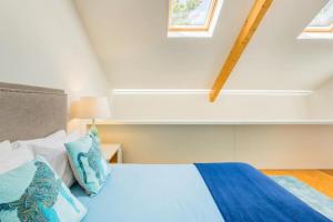 1 dormitorio con 1 cama con almohadas azules y blancas en Hello Porto Firehouse, en Oporto