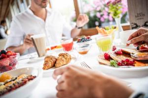 a group of people sitting at a table with breakfast foods at BAD MOOS Dependance "Mühlenhof" in Sesto +58 photos