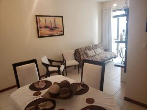 uma sala de estar com uma mesa com chapéus em Lindo e seguro apartamento na Praia do Forte! em Cabo Frio