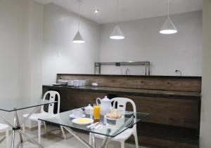 a dining room with a glass table and chairs at Hotel Kusnaya in Piura