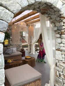 a woman sitting on the floor under a stone archway at Byblos Luxury Villa in Prinos