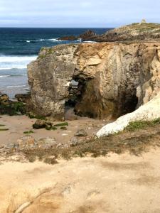 uma caverna ao lado de uma praia rochosa em O Bord de la mer em Saint-Pierre-Quiberon