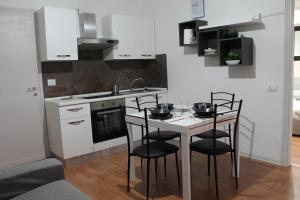 uma cozinha com uma mesa com cadeiras e um lavatório em Appartamento Tilli em Perugia