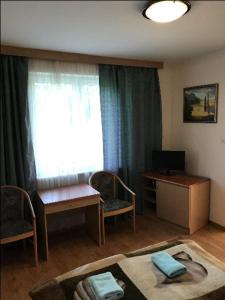 een woonkamer met een tafel, een bureau en een raam bij Gospodarstwo Agroturystyczno-Edukacyjne Gratka in Celiny