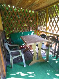 a wooden table and chairs in a gazebo at Agroturystyka pod kasztanem [czynny od maja do września] in Mirsk