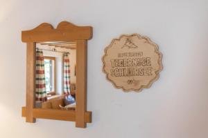 a mirror on a wall with a sign on it at Ferienwohnung Oberrißtraum in Schliersee