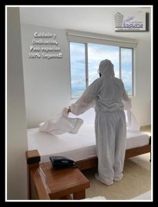una persona está limpiando una cama en una habitación en Hotel La Gran Esquina, en Puerto Boyacá