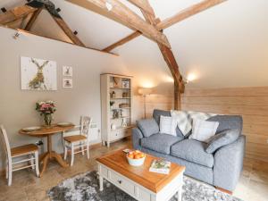a living room with a couch and a table at The Barn at Rapps Cottage in Ilminster