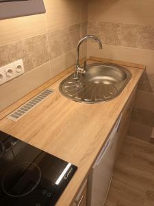 un comptoir de cuisine avec un évier et une cuisinière dans l'établissement Szieszta Szófia Apartman, à Harkány 25 autres photos