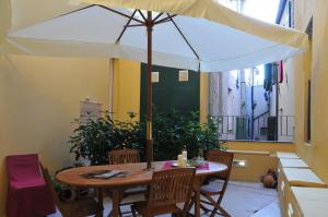 una mesa de madera con una sombrilla en el balcón en Casa Pagliano, en Noli