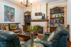 sala de estar con 2 sillas de cuero y chimenea en Casa rural Crisalva, en Granátula de Calatrava