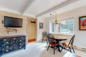 een eetkamer met een tafel en stoelen en een tv bij 1069 Atelier in Sun Valley