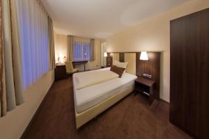ein Schlafzimmer mit einem großen weißen Bett in einem Zimmer in der Unterkunft Hotel - Restaurant Sonneneck in Dornstetten